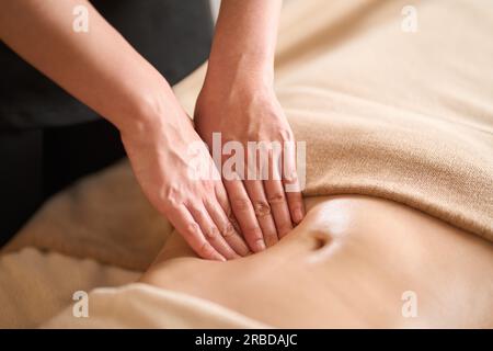 Une femme recevant un massage du ventre dans un salon de beauté Banque D'Images