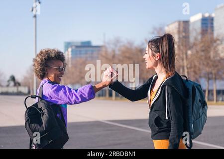 amis serrant la main avant de courir dans la ville Banque D'Images