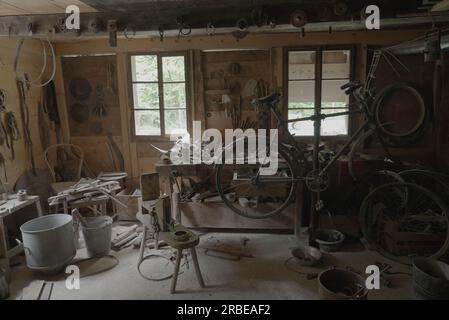 Magasin en bois encombré avec vélo et outils vintage Banque D'Images