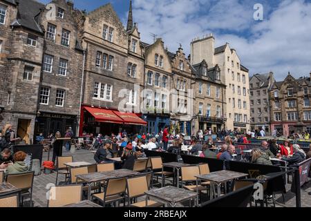 Ville d'Édimbourg, Écosse, Royaume-Uni, les gens aux tables de restaurant sur le quartier populaire de Grassmarket, place du marché historique animée bordée de bars, pubs et resta Banque D'Images