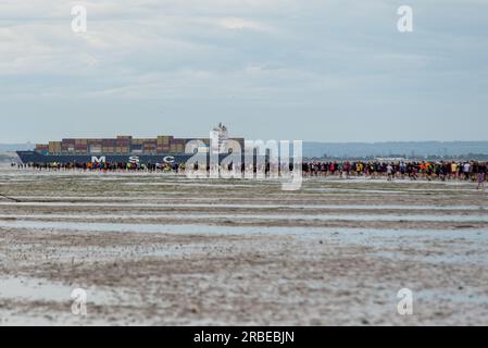 Thorpe Bay, Essex, Royaume-Uni. 9 juillet 2023. Une section du port de Mulberry du jour J de la Seconde Guerre mondiale a été échouée dans l'estuaire de la Tamise à plus d'un mile au large de la côte de Thorpe Bay près de Southend on Sea à la suite de difficultés lorsqu'il a été remorqué en 1944 et s'y trouve depuis. L'immense caisson de Phoenix est accessible à pied brièvement à marée basse, bien que beaucoup aient dû être secourus par la RNLI à mesure que les eaux de mer montent. Cette course de charité amusante d'environ 1800 participants au port et retour a été soigneusement chronométrée et surveillée pour assurer la sécurité des coureurs, les recettes allant à la RNLI Banque D'Images