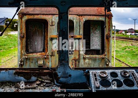 VEW de la cabine d'un vieux train électrique de passagers endommagé - fond coloré avec une focalisation sélective sur le pupitre d'instruments du conducteur Banque D'Images