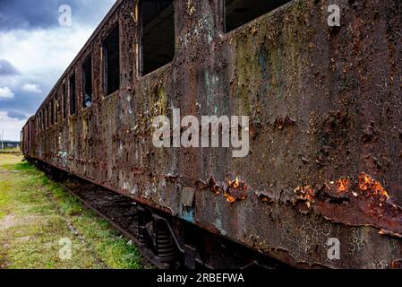 Vieux wagon rouillé de voyageurs abandonné sur le champ de ciment de train Banque D'Images