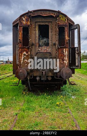 Vieux wagon rouillé de voyageurs abandonné sur le champ de ciment de train Banque D'Images