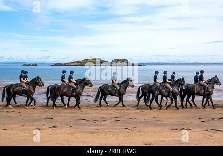 Les membres de la Household Cavalry, Blues et Royals, exercent leurs chevaux le long des sables et dans la mer à Yellowcraig Beach près de North Berwick, East Lothian, après avoir participé plus tôt dans la semaine au service de Thanksgiving pour le roi Charles III à Édimbourg. Date de la photo : dimanche 9 juillet 2023. Banque D'Images