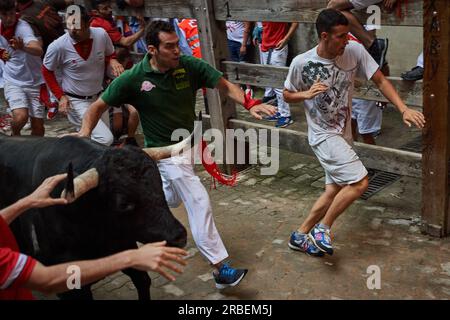 Pamplona, Espagne. 09 juillet 2023. Les coureurs courent à côté d'un taureau du ranch Cebada Gago lors de la troisième course des taureaux des festivités de San Fermín 2023. Troisième course des taureaux des festivités de San Fermín à Pampelune. Six taureaux du ranch Cebada Gago ont couru devant les «mozos» dans une course de taureaux qui a duré deux minutes et quarante secondes sur 800 mètres de longueur (photo par Elsa A Bravo/SOPA Images/Sipa USA) crédit : SIPA USA/Alamy Live News Banque D'Images