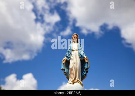 Assomptio de Marie. Statue de la Vierge Marie avec le ciel bleu avec des nuages blancs. Banque D'Images