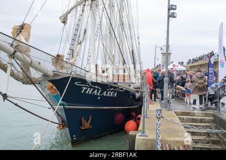 Folkestone, Kent Royaume-Uni. 9 juillet 2023. Le grand voilier Thalassa quittant le port de Folkestone aujourd'hui, commence son voyage de cinq jours à Boulogne en emmenant 60 jeunes du Royaume-Uni et de France pour participer à une variété d'activités sportives. Des centaines de gens bien avisés et du grand public sont venus offrir le bon voyage. Crédit : Xiu Bao/Alamy Live News Banque D'Images