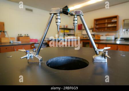 flacon sur une table en résine noire avec un fond de salle de sciences de lycée. Banque D'Images