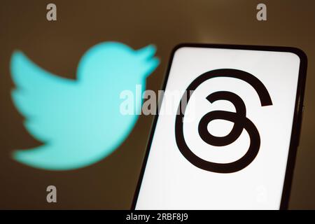 Dans cette illustration photo, le logo threads est affiché sur l'écran d'un smartphone avec un logo Twitter en arrière-plan. Banque D'Images