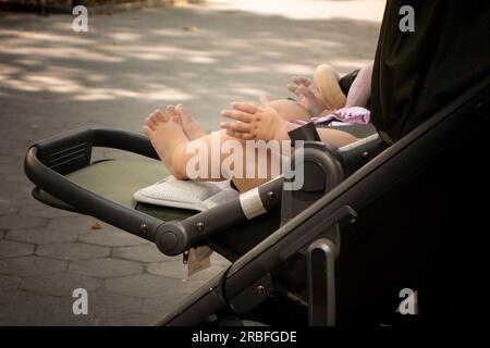 Mains et pieds d'un petit bébé dans une poussette Banque D'Images