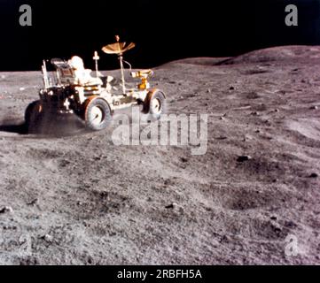 Moon : 23 avril 1972 l'astronaute John Young donne au Lunar Roving Vehicle un entraînement de vitesse dans la course du Grand Prix lors de la troisième activité extravéhiculaire Apollo 16 sur le site d'atterrissage de Descartes. Banque D'Images