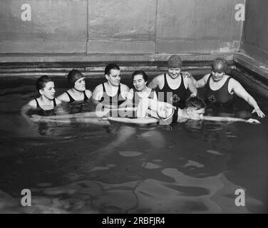 Chicago, Illinois : c. 1930 deux instructeurs de la Croix-Rouge américaine donnant un cours de sauvetage dans une piscine. Banque D'Images