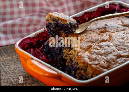 Cobbler aux myrtilles fraîchement cuit dans un plat allant au four avec fourchette. Cobbler aux baies maison, gros plan Banque D'Images