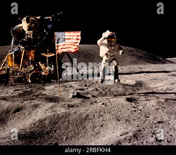 Lune : 21 avril 1972 l'astronaute John Young, commandant de la mission d'atterrissage lunaire Apollo 16, saute de la surface lunaire alors qu'il salue le drapeau américain sur le site d'atterrissage de Descartes lors de la première activité extravéhiculaire de la mission. Le module lunaire et le Lunar Roving Vehicle sont à gauche. Banque D'Images