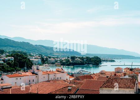 Vue panoramique de la ville de Rab avec des toits de tuiles rouges et des montagnes à l'horizon. Île de Rab, Croatie. Banque D'Images