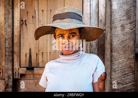 Portrait femme malgache ethnique Sakalava avec femme à la peau foncée au visage peint jaune, Morondava, Madagascar, Afrique Banque D'Images