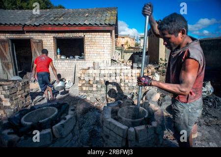 Artisan fabriquant des pots en aluminium, Ambatolampy, Antsirabe, Centre de Madagascar, Madagascar. Le métal utilisé pour fabriquer les pots est récupéré dans la voiture p Banque D'Images