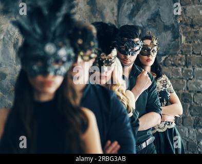 Groupe de personnes dans masquerade masque carnaval posing in studio. Belles femmes et hommes portant le masque de Venise. Fashion, party, amis concept Banque D'Images