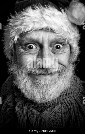 Portrait noir et blanc d'un homme adulte avec barbe blanche déguisé en Père Noël pour les vacances de Noël Banque D'Images