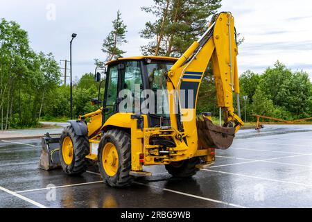 Chargeuse-pelleteuse sur pneus jaune sur le site. Machinerie lourde. tracteur et bulldozer ou excavateur. Équipement multifonctionnel Banque D'Images