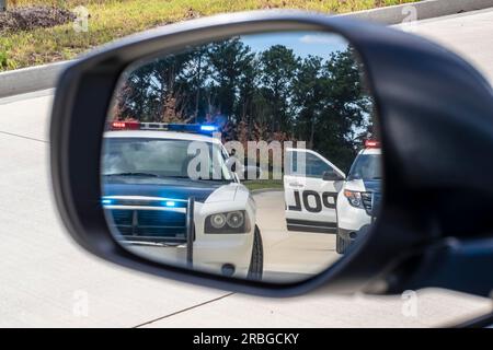 Deux véhicules de police arrêtent une berline lors d'un arrêt de circulation de routine Banque D'Images