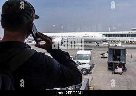 Un jeune voyageur appelle les forces de l'ordre après avoir vu quelque chose de suspect dans un aéroport international Banque D'Images