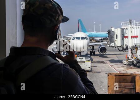 Un jeune voyageur appelle les forces de l'ordre après avoir vu quelque chose de suspect dans un aéroport international Banque D'Images