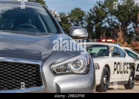 Deux véhicules de police arrêtent une berline lors d'un arrêt de circulation de routine Banque D'Images