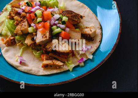 Poulet doner kebab, sandwich doner kebab turc sur pain pita maison avec salade fraîche et sauce Chili maison et sauce au yaourt à l'ail. Banque D'Images