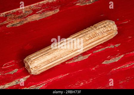 goupilles simples en chêne sur fond usé peint en rouge, goupilles utilisées pour joindre deux morceaux de bois, joint, menuiserie Banque D'Images