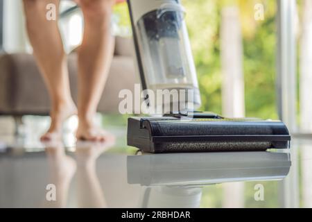 Aspirateur moderne sans fil avec buse d'eau pour nettoyer les sols. Gros plan d'un aspirateur à laver sur le sol nettoyage de maison Banque D'Images