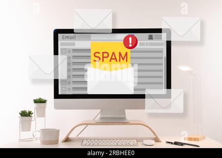 Message d'avertissement de spam dans le logiciel de messagerie. Des illustrations d'enveloppes sortent de l'écran de l'ordinateur sur le bureau Banque D'Images