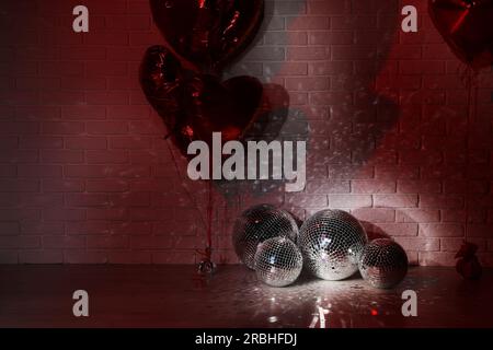 Beaucoup de boules disco brillantes dans la chambre décorées avec des ballons en forme de coeur, de couleur tonique Banque D'Images