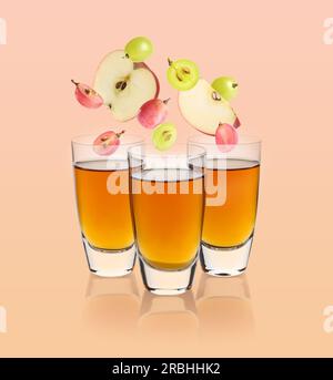 Nectar de pomme et de raisin fraîchement préparé sur fond beige. Fruits tombant dans des verres Banque D'Images