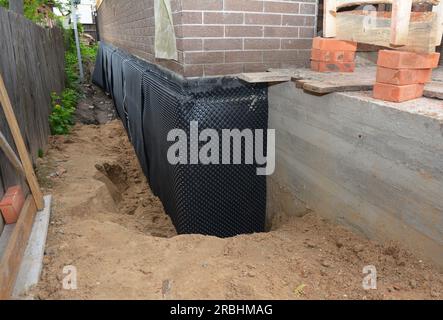 Imperméabilisation du sous-sol avec tapis de fossette, drain de fossette dans la zone de coin problématique. Isolation de mur de fondation de maison avec panneau de mousse rigide, imperméabilisant moi Banque D'Images