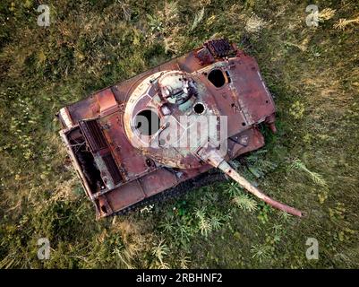 Détruit rouillé, abandonné et brûlé le char de combat dans les champs verts au coucher du soleil. Vous pouvez utiliser cette image comme illustration par exemple guerre Banque D'Images