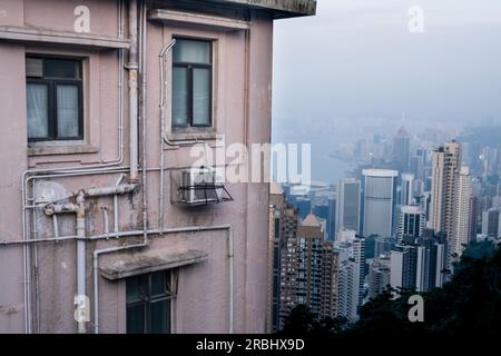 Vues incroyables sur la ville depuis le Lugard Road Lookout sur Victoria Peak, Hong Kong, un soir d'été alors que la dernière lumière du jour frappe les tours. Banque D'Images