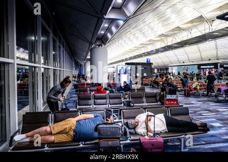 Longues escales et passagers fatigués dormant sur des sièges dans leurs vêtements la nuit à l'aéroport de Hong Kong, Hong Kong, Asie. Photo : Rob Watkins Banque D'Images