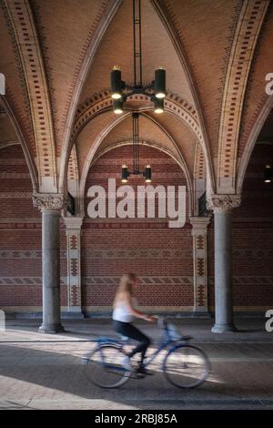 Femme sur des promenades à vélo à travers le portail du Rijksmuseum (Rijksmuseum), Amsterdam, province de Hollande du Nord, pays-Bas, Europe Banque D'Images