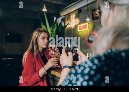 Deux copines prenant Une photo dans Un bar à cocktails. Banque D'Images