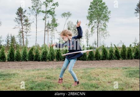 jeune fille dans son jardin jouant avec un hula hoop Banque D'Images