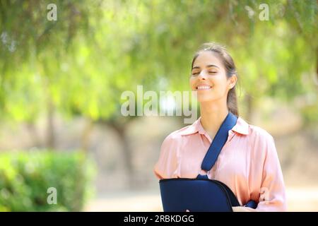 Heureuse femme convalescente respirant de l'air frais dans un parc verdoyant Banque D'Images