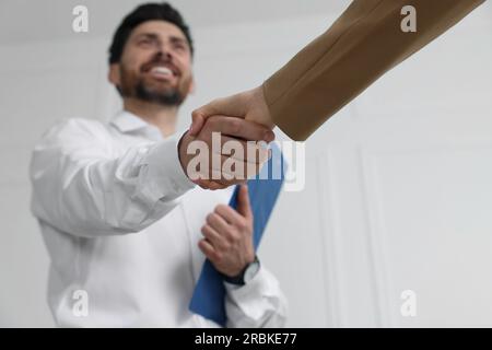 Gestionnaire des ressources humaines serrant la main avec le candidat lors de l'entretien d'embauche dans le bureau, focalisation sélective Banque D'Images