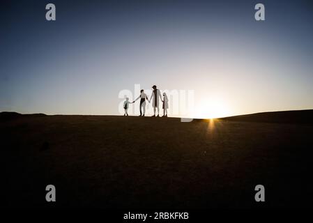 Silhouette de famille sur une colline en été Banque D'Images