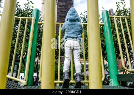 vue de la petite fille de derrière debout sur les orteils de la pointe sur le terrain de jeu Banque D'Images