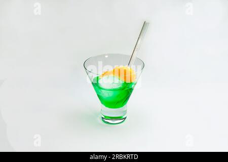 Un cocktail vert avec une paille à boire et mandarine découpée en studio sur fond blanc Banque D'Images