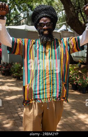 Heureux Rastafari personne portant des vêtements colorés et chapeau de laine, ayant des dreadlocks et une façon positive de penser, anneau de paix sur son doigt Banque D'Images