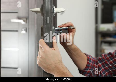 Handyman changeant noyau de serrure de porte à l'intérieur, closeup Banque D'Images