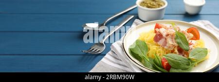 Savoureuse courge spaghetti au bacon et basilic servie sur une table en bois bleu. Conception de bannière avec espace pour le texte Banque D'Images